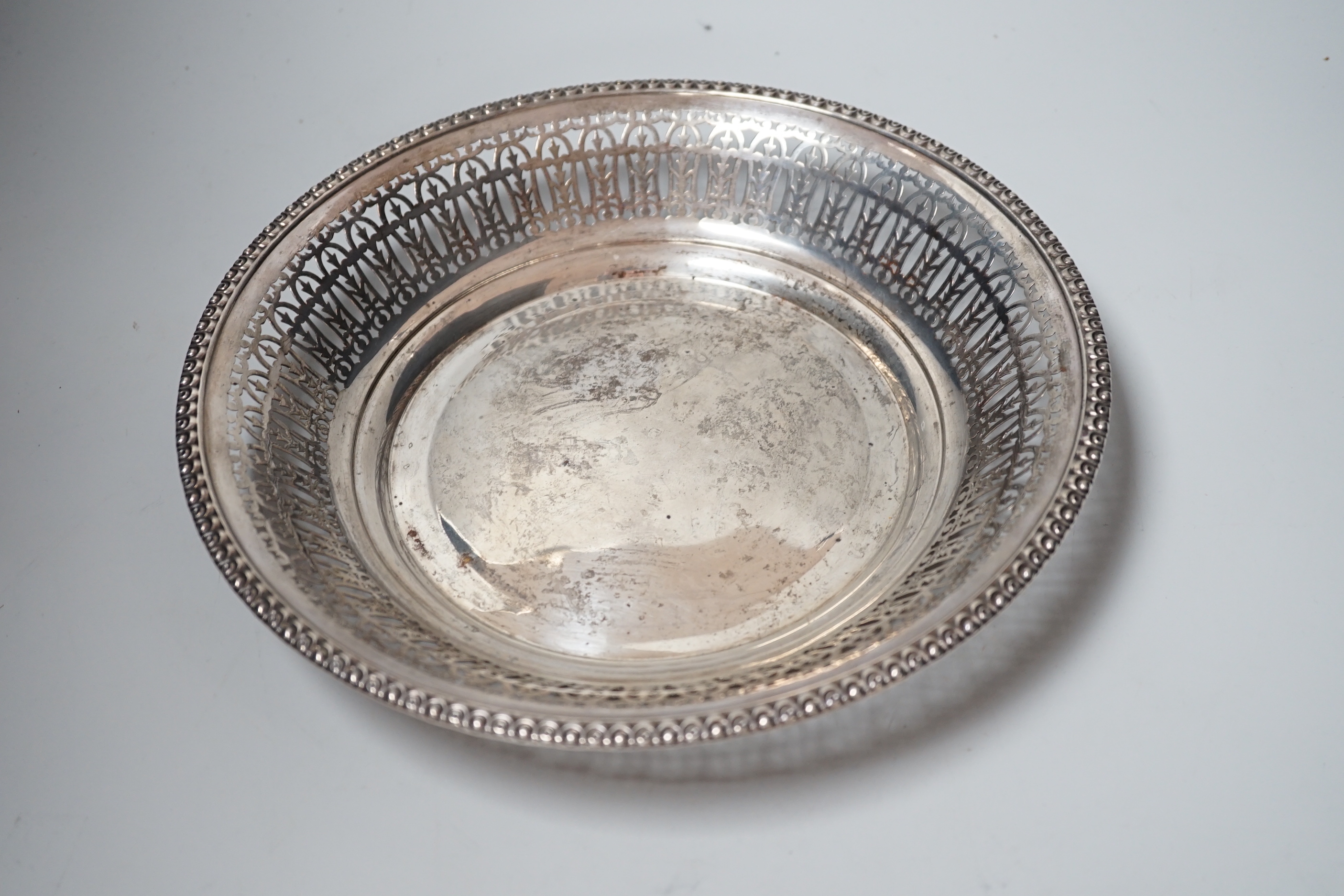 A late Victorian silver tea strainer, import marks for London, 1900 and a pierced silver plated bowl.